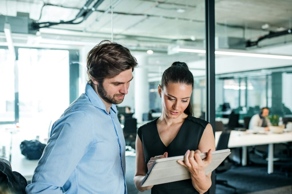 Young businesspeople with tablet in an office, working