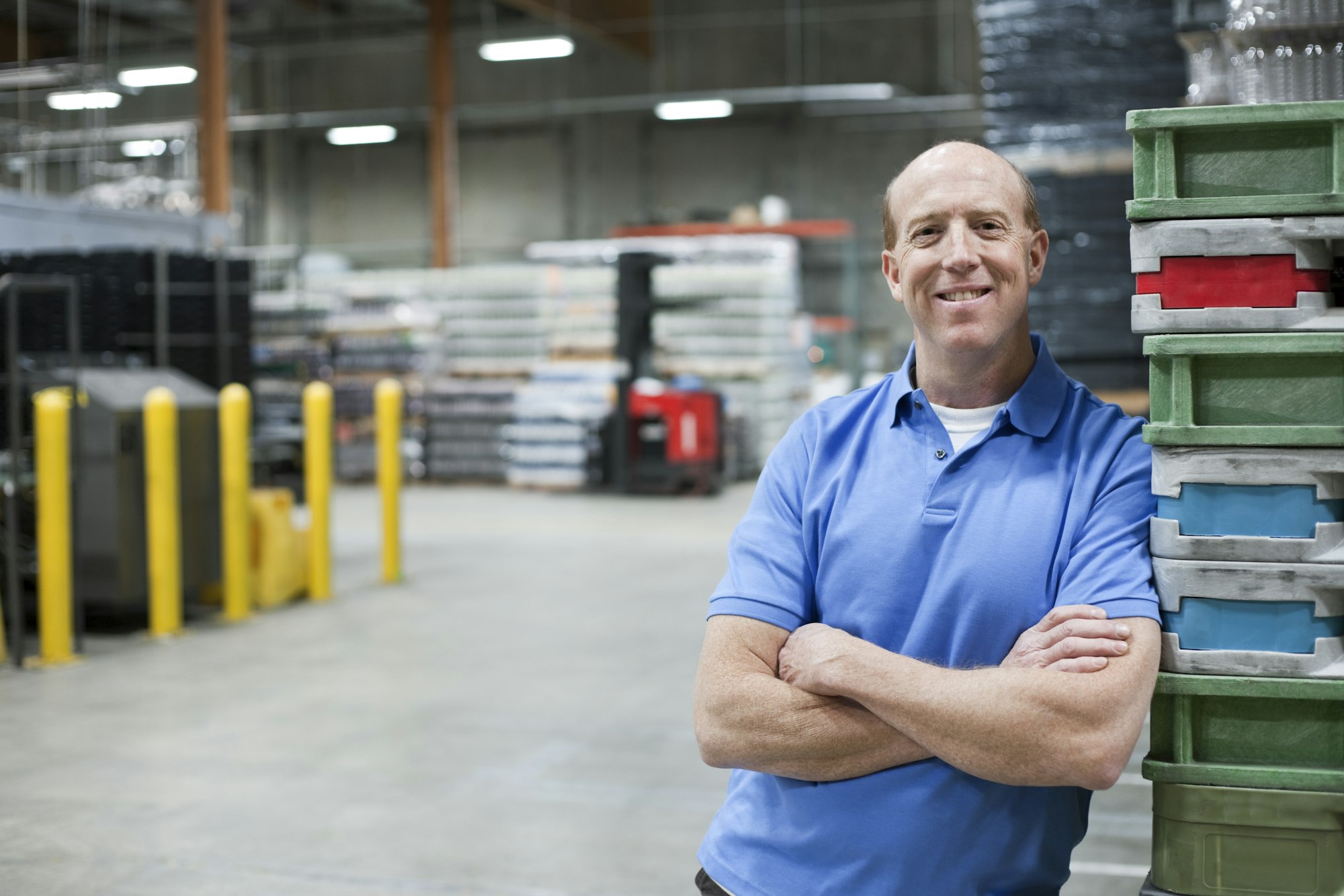 A portrait of a Caucasian male warehouse worker in a large warehouse facility.