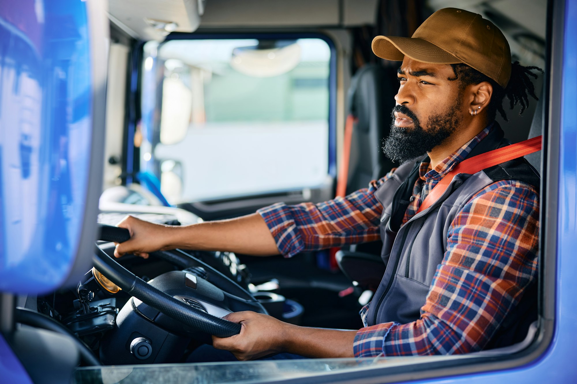 Black professional driver driving a truck.