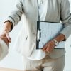 cropped view of recruiter and employee shaking hands in office